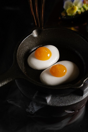 The marshmallow sunny side-up is served theatrically on a bed of dry ice, bringing guests both visual and edible delight.