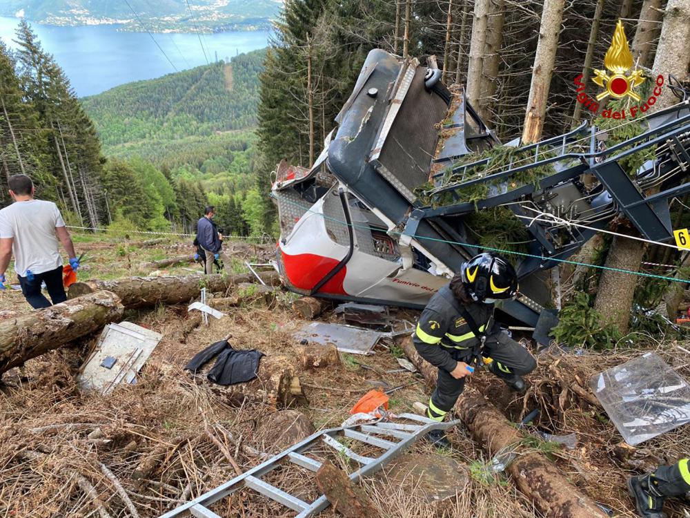 Rescuers work by the wreckage of a cable car after it collapsed near the summit of the Stresa-Mottarone line in the Piedmont region, northern Italy, Sunday, May 23, 2021. Rescuers work by the wreckage of a cable car after it collapsed near the summit of the Stresa-Mottarone line in the Piedmont region, northern Italy, Sunday, May 23, 2021.