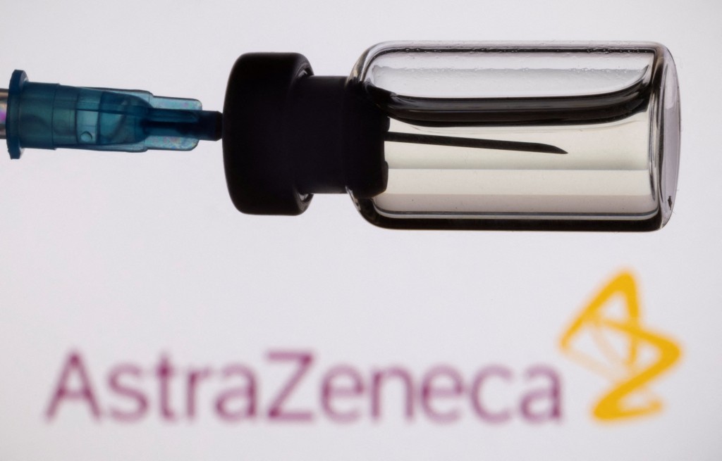 A vial and a syringe are seen in front of a displayed AstraZeneca logo, in this illustration taken, November 27, 2021. REUTERS