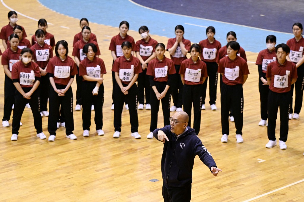 Photo by GREG BAKER / AFP  Coach Jiro Omi talks to students of Nippon Sports Science University during rehearsals for their annual synchronised walking performance, known as Shudankodo, in Yokohama on November 26, 2025.