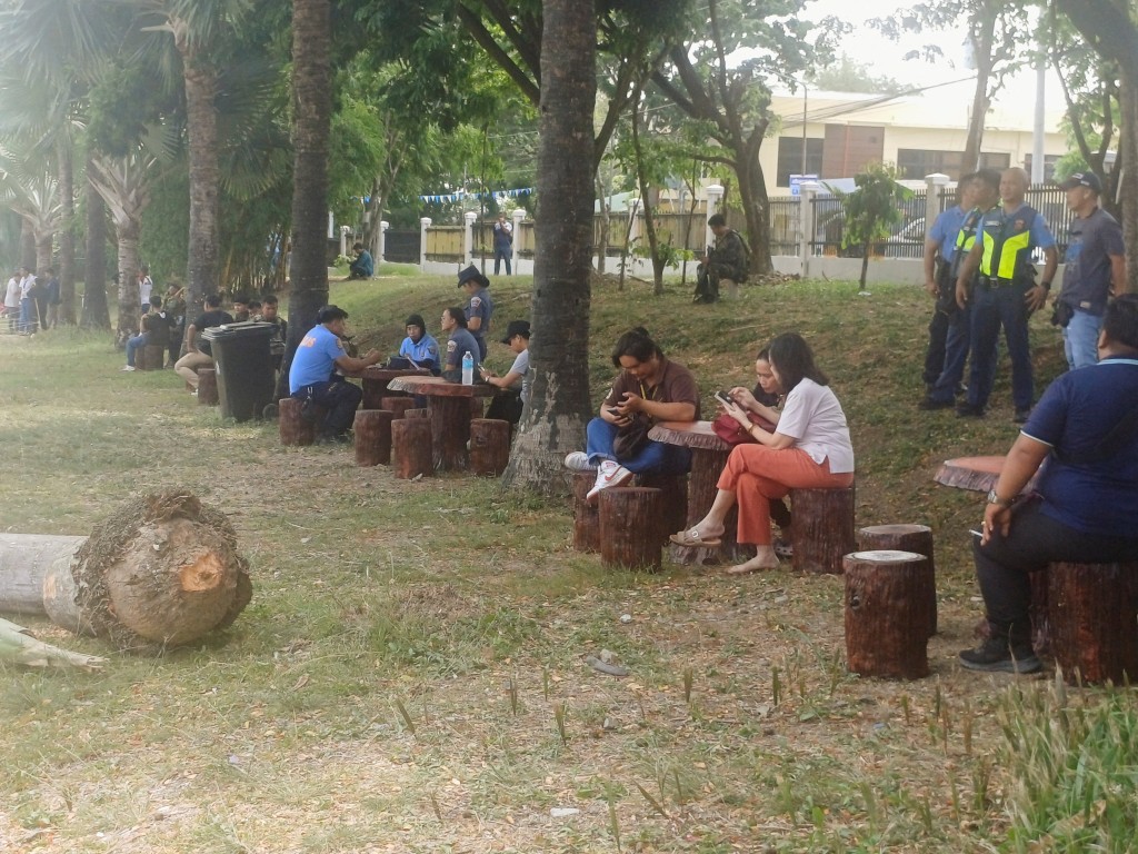 People sit outside Ateneo de Zamboanga University after a shooting that killed two people, in Zamboanga, southern Philippines, August 18, 2026. REUTERS/Nonoy Lacson