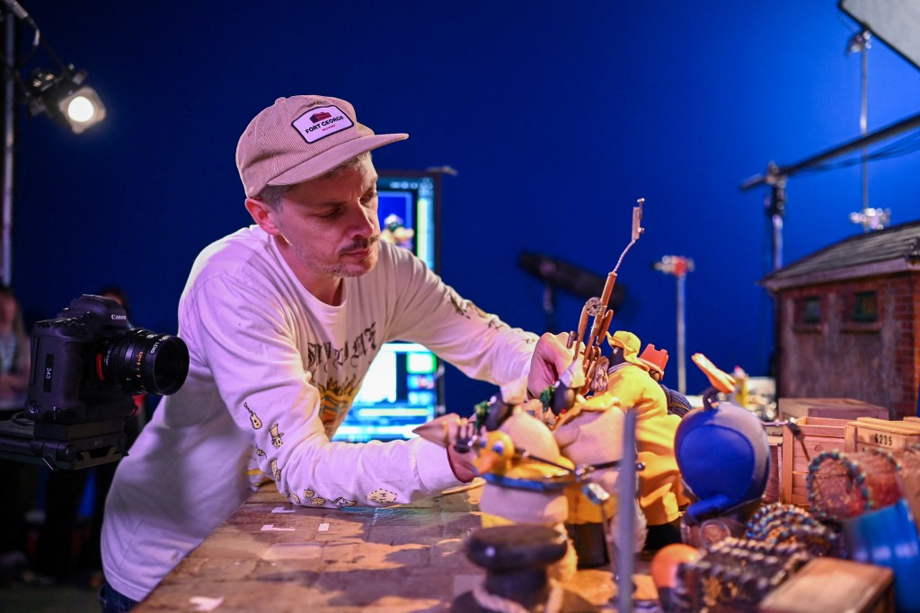 Photo by BEN STANSALL / AFP This photo taken on March 4, 2026 shows Ed Jackson, an animator for 'Shaun the Sheep: The Beast of Mossy Bottom', working on a set at Aardman Animations studios in Bristol, western England.