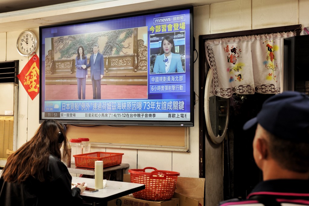 A television shows the meeting between Kuomintang (KMT) chairwoman Cheng Li-wun and Chinese President Xi Jinping in Beijing, at a restaurant in Taipei on April 10, 2026. (Photo by I-Hwa Cheng / AFP)