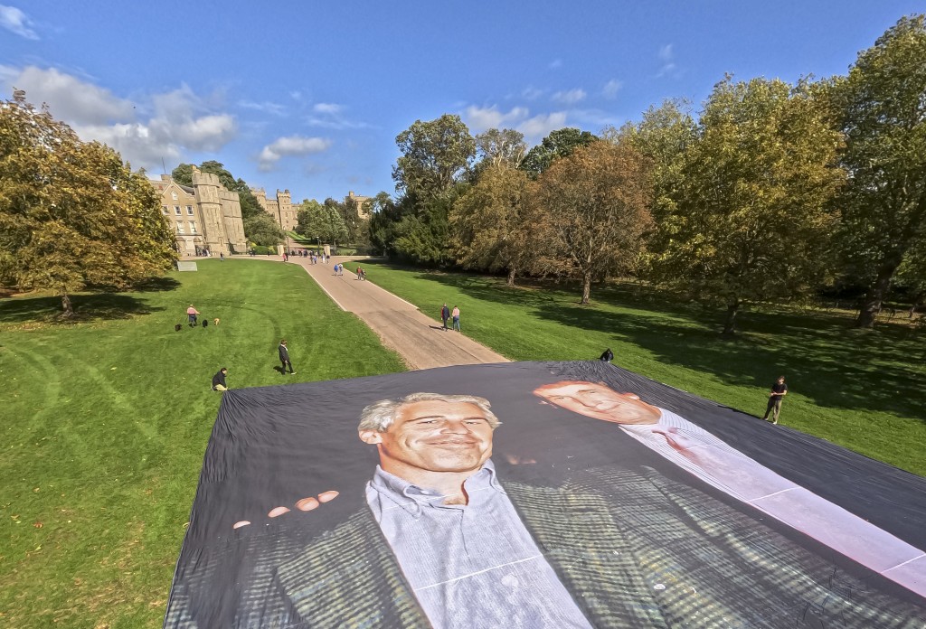 A handout image from the UK collective 'Everyone Hates Elon' shows activists unfurling a large photo depicting US President Donald Trump posing with Jeffrey Epstein, on the Long Walk, outside Windsor Castle in Windsor, on September 15, 2025, ahead of a State visit by the US president. (Photo by Everone Hates Elon / AFP)