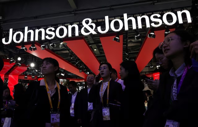 People gather next to a logo of Johnson & Johnson at the company’s booth at the 8th China International Import Expo (CIIE) in Shanghai, China, November 6, 2025.REUTERS/Maxim Shemetov 
