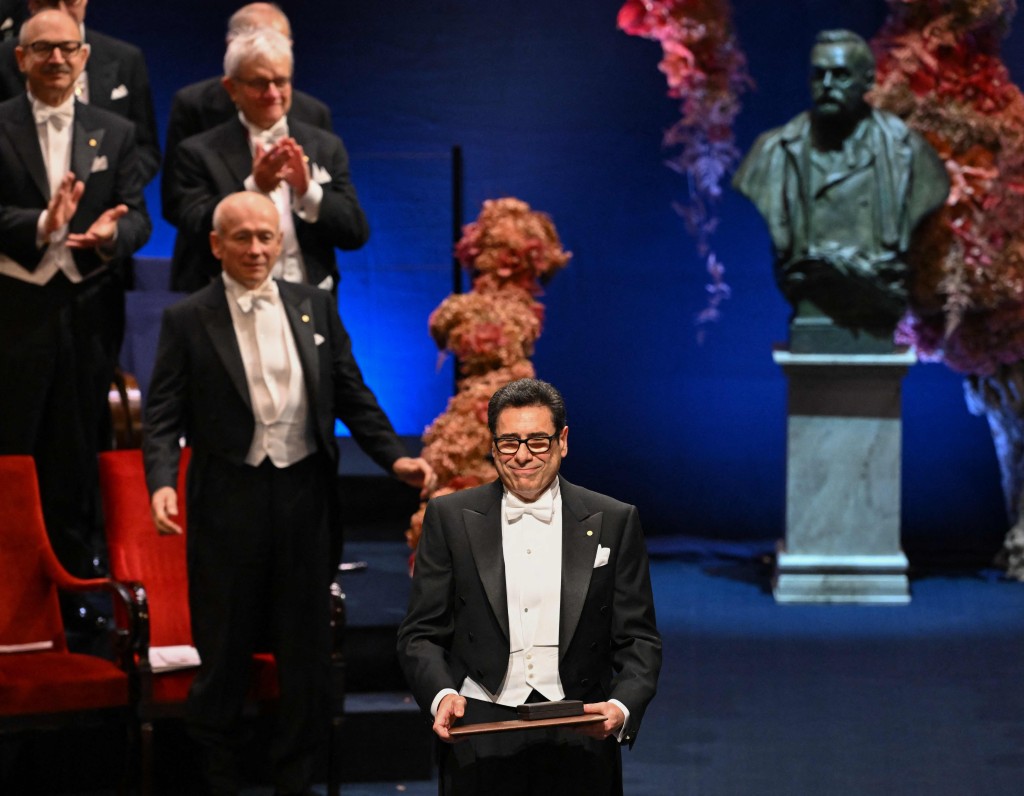 laureate of The Sveriges Riksbank Prize in Economic Sciences 2025 French economist Philippe Aghion poses on stage with his award during the 2025 Nobel Prize award ceremony on December 10, 2025 in Stockholm, Sweden. The laureates received their prizes at formal ceremonies in Stockholm and Oslo on December 10. That date is the anniversary of the death in 1896 of scientist Alfred Nobel, who created the prizes in his will. (Photo by Jonathan Nackstrand / AFP)