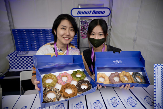 Donut Demo owner Yiyan, left, introduces doughnuts with salted egg flavor and bean paste with condensed milk flavor.