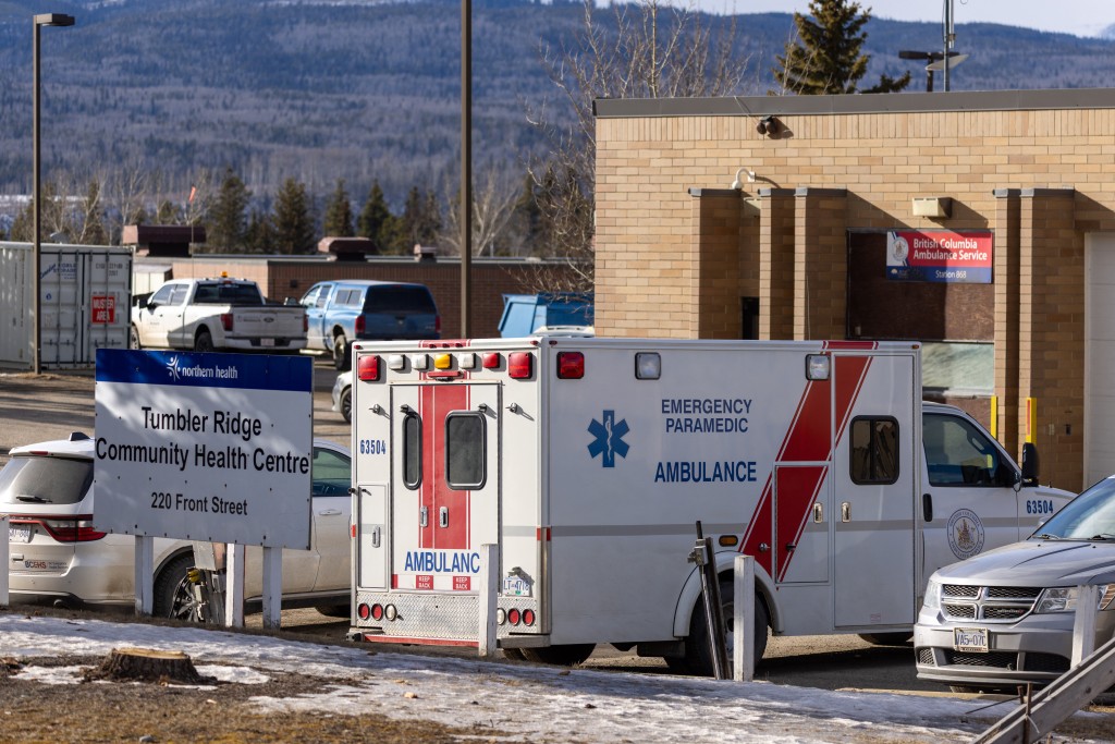 Photo by EAGLE VISION AGENCY / AFP  An ambulance is parked at the Community Health Center in Tumbler Ridge, a small town in British Columbia, on February 11, 2026, a day after a shooting took place, leaving at least nine people dead.
