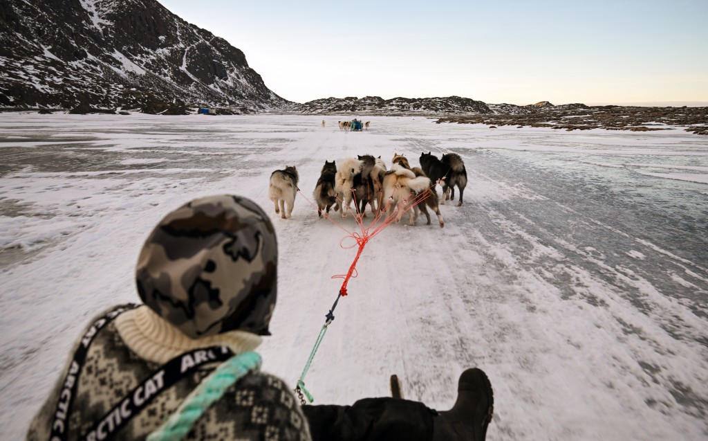 Photo by INA FASSBENDER / AFP  Musher Nukaaraq Lennert Olsen rides with his sled dogs near the "dog town" of Sisimiut, Greenland on January 31, 2026.