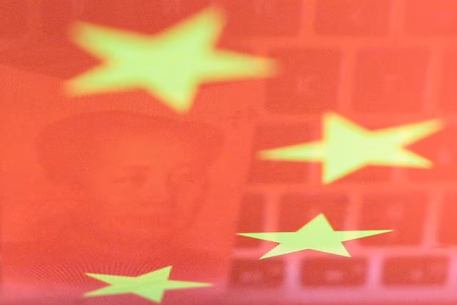 A China yuan banknote featuring late Chinese chairman Mao Zedong and a computer keyboard are seen reflected on an image of Chinese flag in this illustration picture taken November 1, 2019. REUTERS/Florence Lo/Illustration/File Photo 