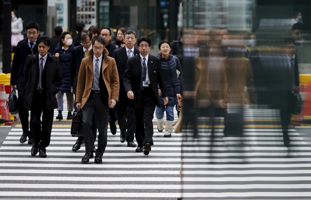  People are reflected on a wall as they cross a road at Tokyo's business district, Japan, February 22, 2016. REUTERS/Toru Hanai/Files
