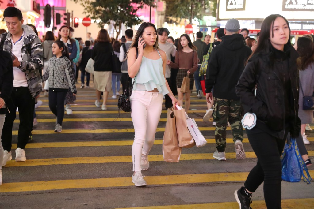 Shoppers cross the road outside a Causeway Bay shopping mall. Reuters