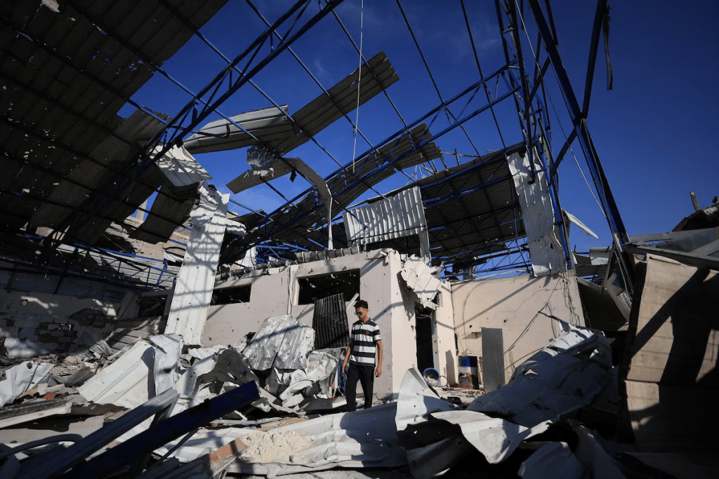 A Palestinian young man stands amid the debris of Al-Hassayna family’s company warehouse, damaged during the war, in Gaza City, September 28, 2026. REUTERS/Dawoud Abu Alkas