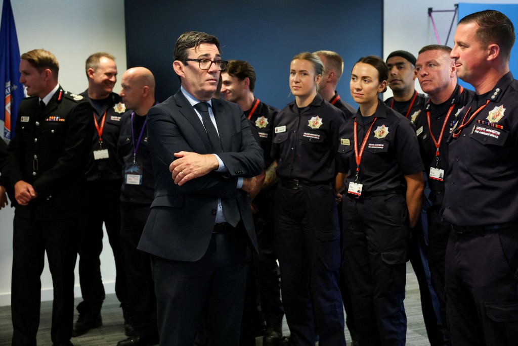 Mayor of Greater Manchester, Andy Burnham talks with members of Great Manchester Fire and Rescue Service during a visit to the Greater Manchester Police headquarters on October 3, 2025, following an attack at Heaton Park Hebrew Congregation synagogue yesterday. Prime Minister Keir Starmer visited Friday the scene of an attack outside a Manchester synagogue that killed two people and seriously injured three on a Jewish holiday. (Photo by Phil Noble / POOL / AFP)