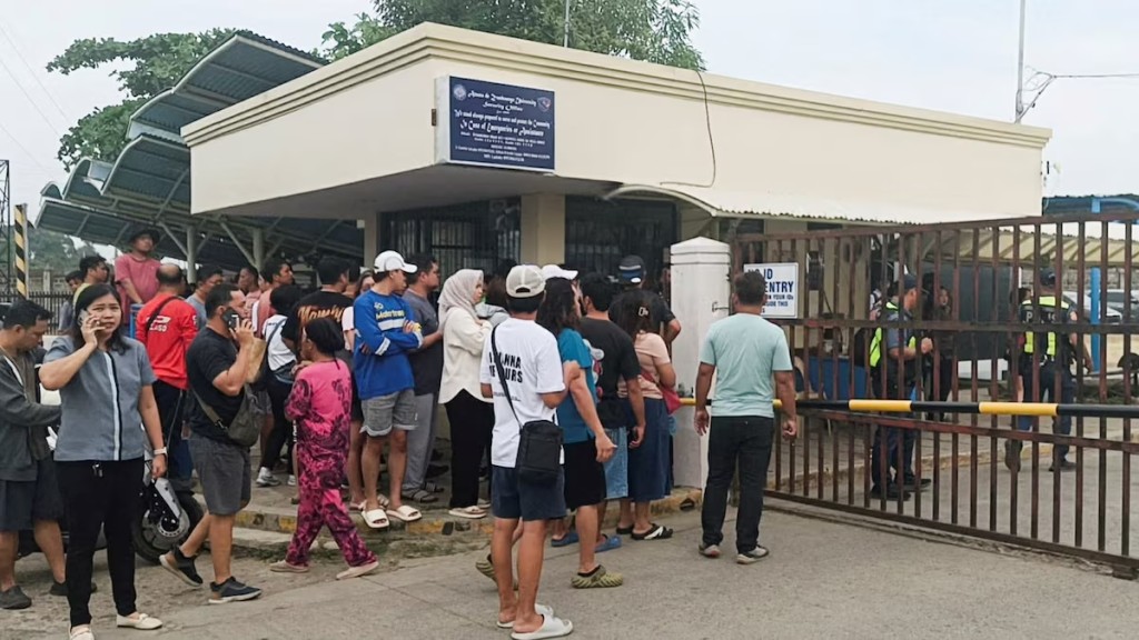 People stand outside Ateneo de Zamboanga University after a shooting that killed two people, in Zamboanga, southern Philippines, August 18, 2026. REUTERS/Nonoy Lacson