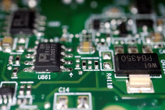 Semiconductor chips are seen on a printed circuit board in this illustration picture taken February 17, 2023. REUTERS/Florence Lo/Illustration/File Photo