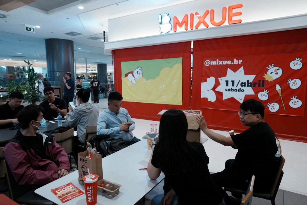 Employees of Chinese ice cream and beverage chain Mixue take a rest outside the company's first Brazilian store ahead of its opening to the public, marking the brand's arrival in South America amid a fresh tide of Chinese investment, in Sao Paulo, Brazil, April 9, 2026. REUTERS/Alexandre Meneghini