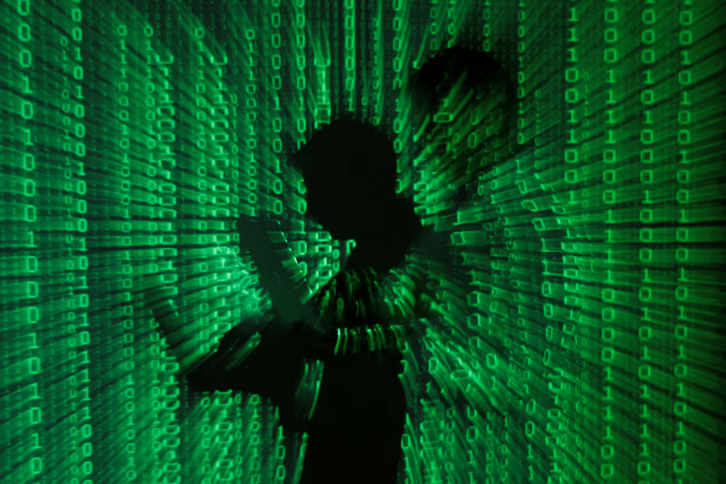 An illustration picture shows a projection of binary code on a man holding a laptop computer, in an office in Warsaw June 24, 2013. REUTERS/Kacper Pempel/Illustration/File Photo 