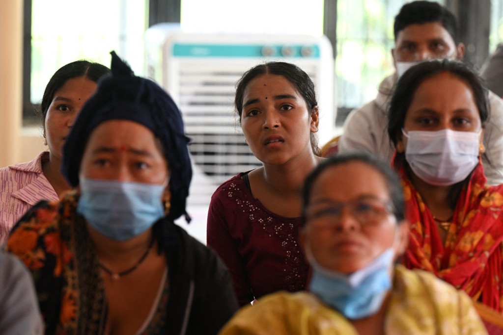 Photo by PRAKASH MATHEMA / AFP  Relatives look at a screen to identify deceased victims at a mortuary, after flash floods hit Bharatpur in Nepal's Chitwan district on September 1, 2026.