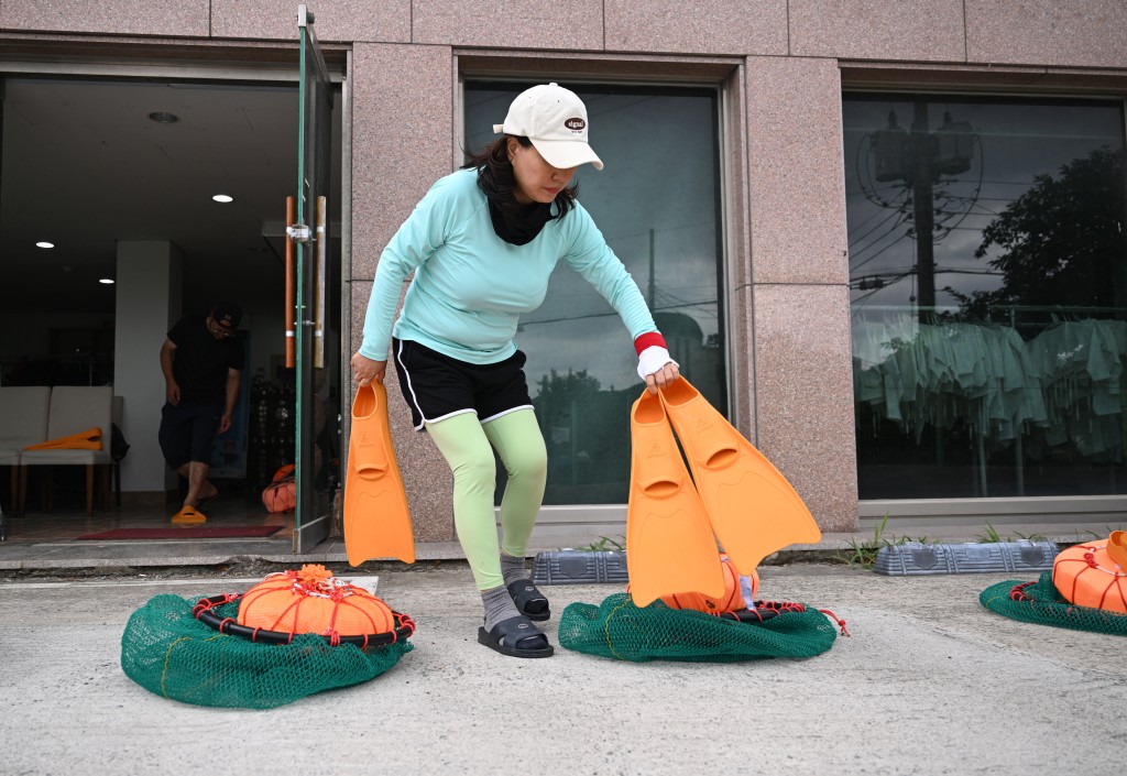 Photo by JUNG YEON-JE / AFP  This picture taken on August 12, 2026 shows South Korean haenyeo Choi Young-hee, who runs an organisation teaching haenyeo culture and training aspiring divers, preparing for a haenyeo training session in the South Korean coastal town of Geoje.