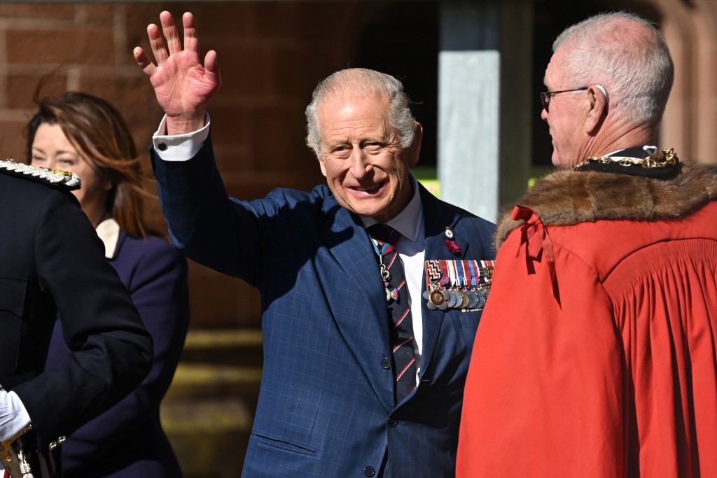 Britain's King Charles III waves to well-wishers as he arrives at the Town Hall in Barrow-in-Furness, northern England on September 22, 2025, to present Letters Patent formally bestowing Royal Charter status for the Port of Barrow, in recognition of the town’s critical contribution to national defence and industry. (Photo by Paul ELLIS / AFP)