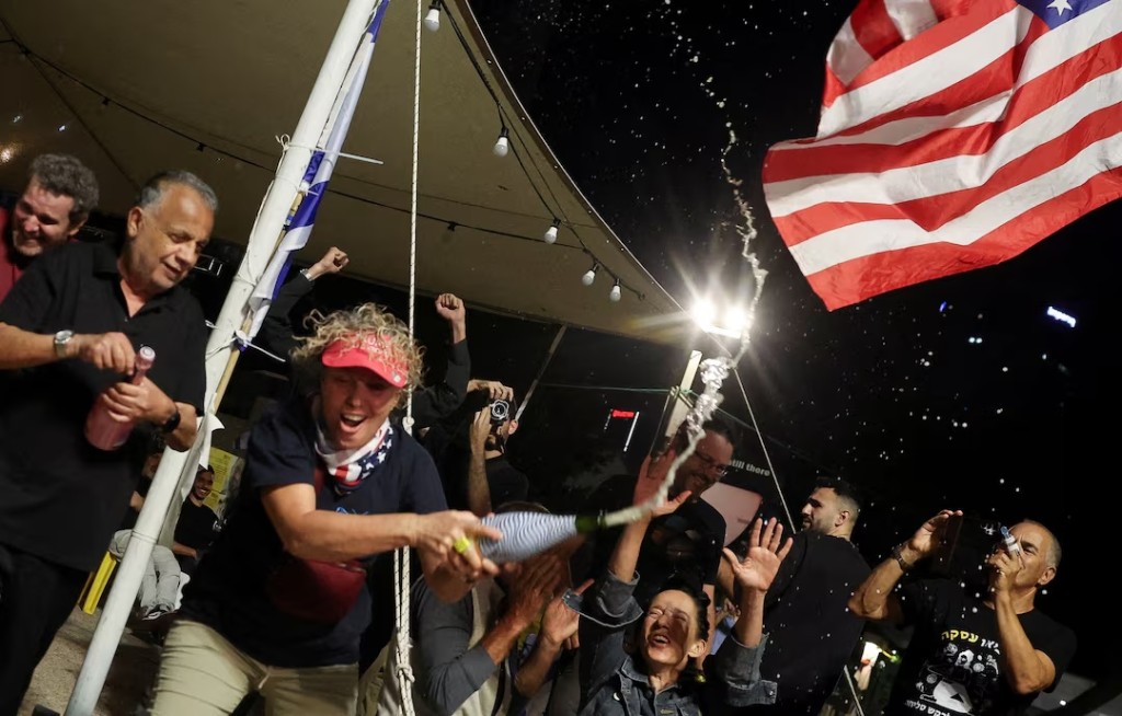 People celebrate after U.S. President Donald Trump announced that Israel and Hamas agreed on the first phase of a Gaza ceasefire, at the "Hostages square", in Tel Aviv, Israel, October 9, 2025. REUTERS/Ronen Zvulun