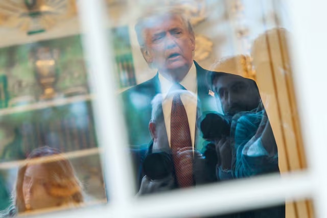 News photographers wait for U.S. President Donald Trump to walk out of the Oval Office to speak with reporters at the White House in Washington, D.C., U.S., April 13, 2026. REUTERS/Jonathan Ernst/File Photo 