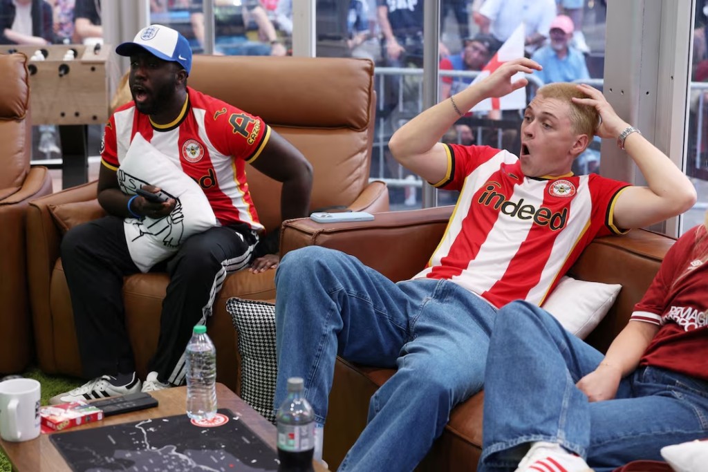  Soccer Football - FIFA World Cup 2026 - New York City, New York, U.S. - July 15, 2026 Chief World Cup Watchers Kevin Akoto and Austin Franklin react during the England v Argentina FIFA World Cup Semi Final match in their World Cup Watcher Box located in Times Square REUTERS/John Sibley