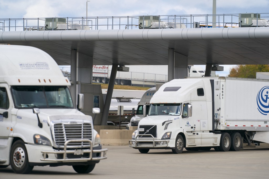 Commercial trucks cross into Canada from the US at the Blue Water Bridge border crossing in Sarnia, Ontario, on October 24, 2025. (AFP)