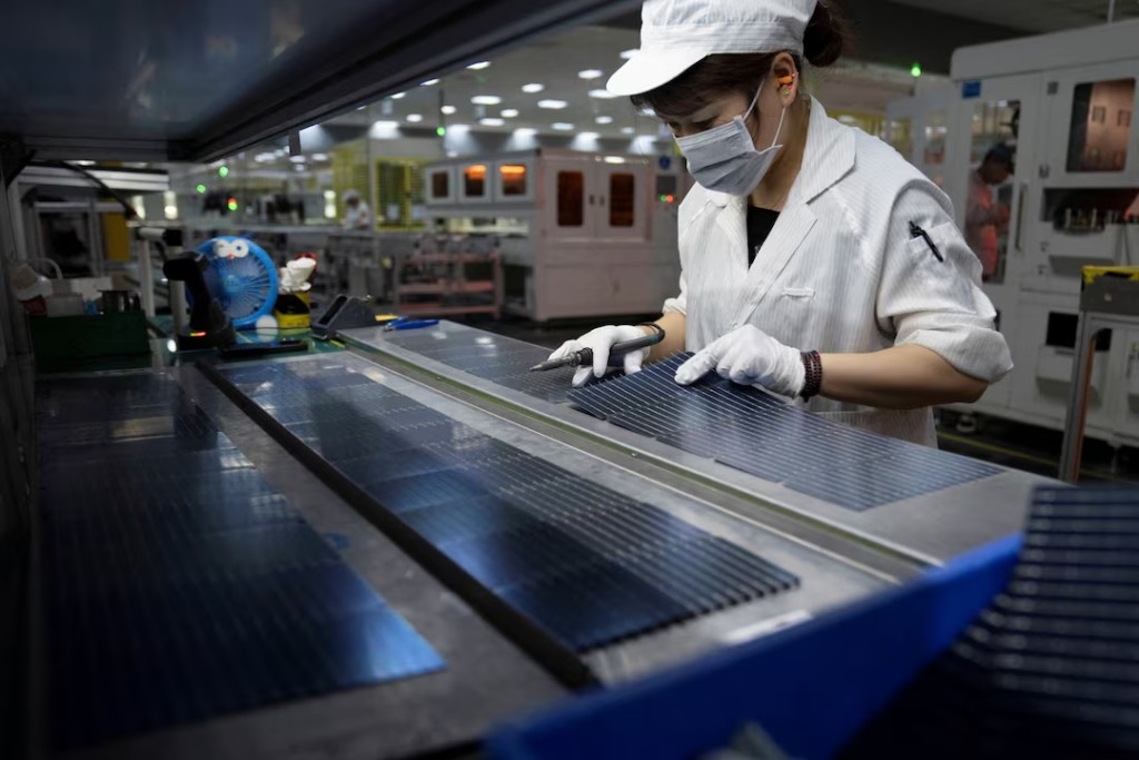 An employee works on the production line for solar panels at a factory of GCL System Integration Technology in Hefei, Anhui province, China May 16, 2024. China Daily via REUTERS/File Photo 