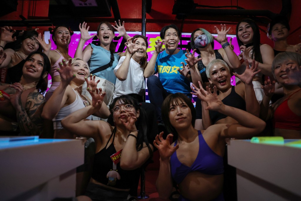 Staffers at Muscle Girls pose for a photo with female customers in Tokyo, Japan, July 25, 2025. REUTERS/Kim Kyung-Hoon