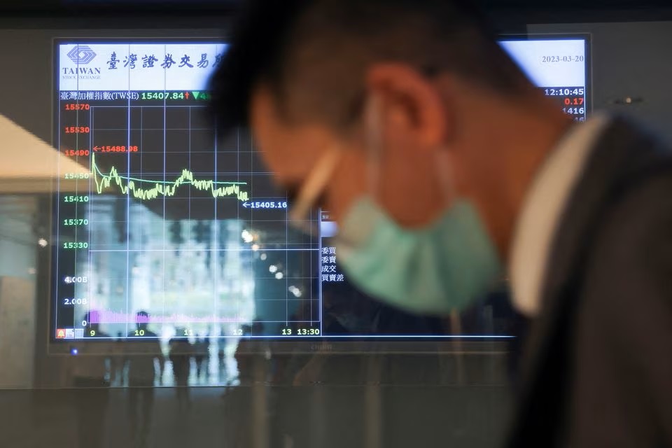A man wearing a face mask passes in front of screens showing trading data while using an escalator outside Taiwan Stock Exchange in Taipei. (Reuters) A man wearing a face mask passes in front of screens showing trading data while using an escalator outside Taiwan Stock Exchange in Taipei. (Reuters)