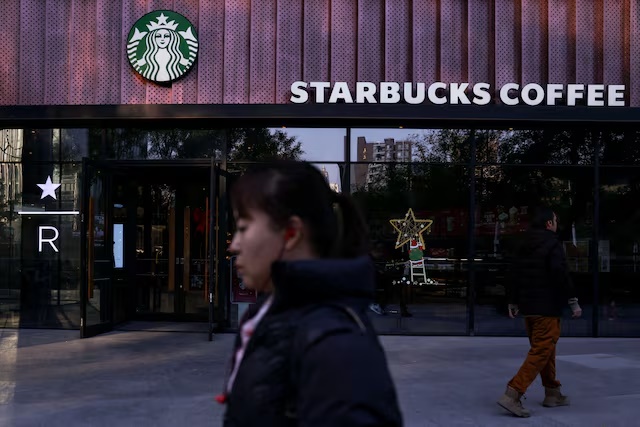 People walk past a Starbucks coffee shop in Beijing, China, November 4, 2025. REUTERS/Tingshu Wang/File Photo