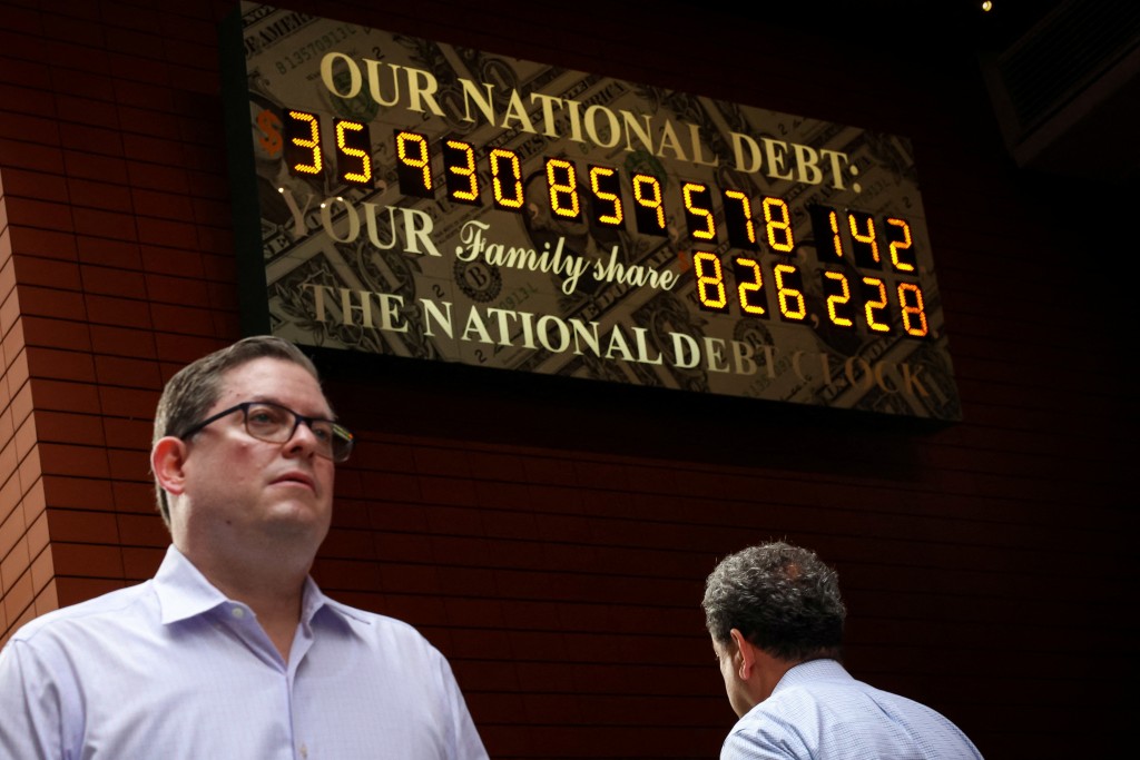 People pass by the National Debt Clock in New York City.  REUTERS