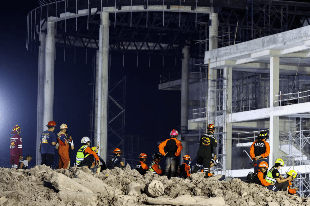 Rescue personnel stand and sit at the site of a building that collapsed after a strong earthquake struck central Myanmar on Friday, earthquake monitoring services said, which affected Bangkok as well with people pouring out of buildings in the Thai capital in panic after the tremors, in Bangkok, Thailand, March 28, 2025. REUTERS/Athit Perawongmetha Rescue personnel stand and sit at the site of a building that collapsed after a strong earthquake struck central Myanmar on Friday, earthquake monitoring services said, which affected Bangkok as well with people pouring out of buildings in the Thai capital in panic after the tremors, in Bangkok, Thailand, March 28, 2025. REUTERS/Athit Perawongmetha