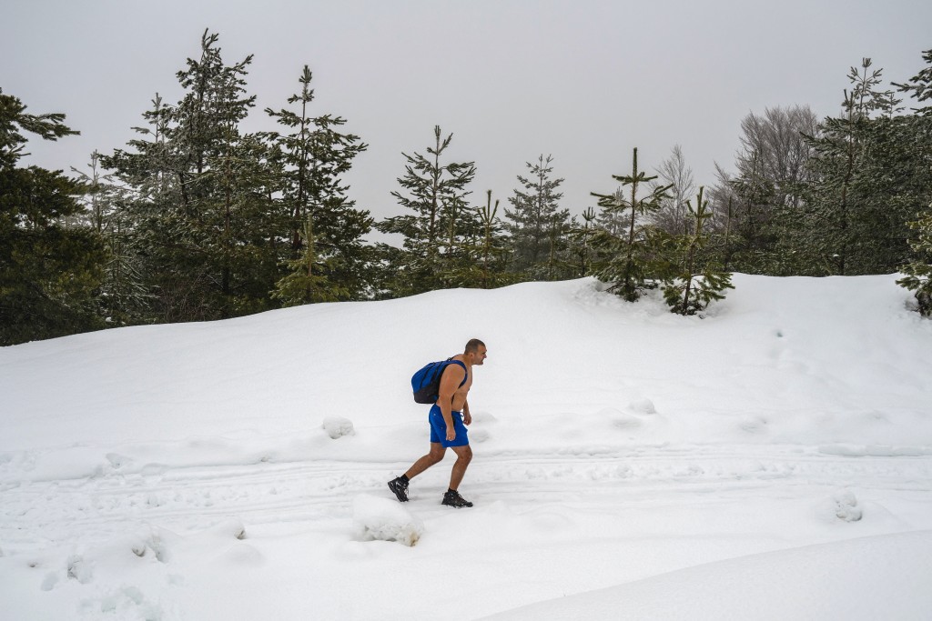 Photo by OLIVER BUNIC / AFP  Serbian archaeologist Vladimir Stevanovic, known on social media as "Serbia's Iceman", hiking wearing only boots, shorts and a backpack on thick snow at the Besna Kobila mountain in Serbia's far south, near the city of Vranje, on January 30, 2026.