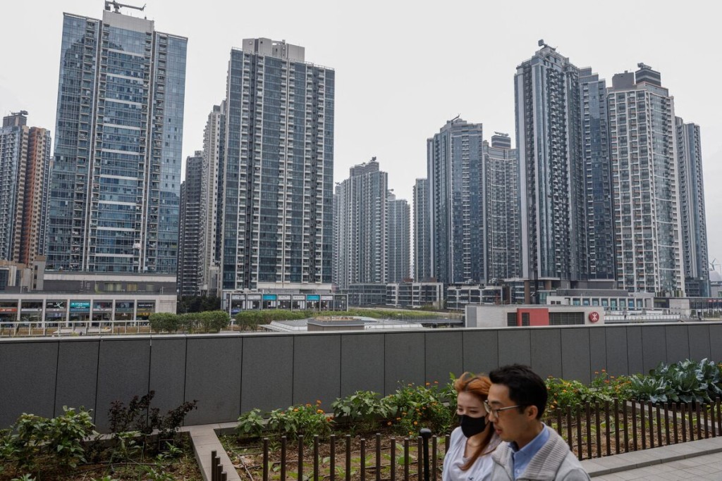 People walk in front of residential buildings, in Hong Kong, China, February 27, 2024. REUTERS