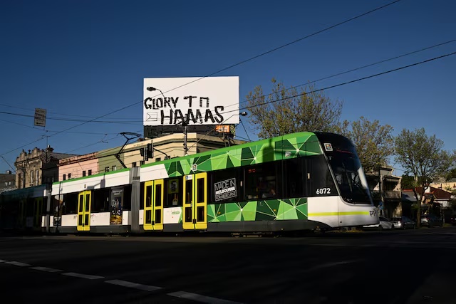Graffiti reading "Glory to Hamas" is seen on a billboard above a shop in Melbourne, Australia, October 7, 2025. AAP/Joel Carrett via REUTERS