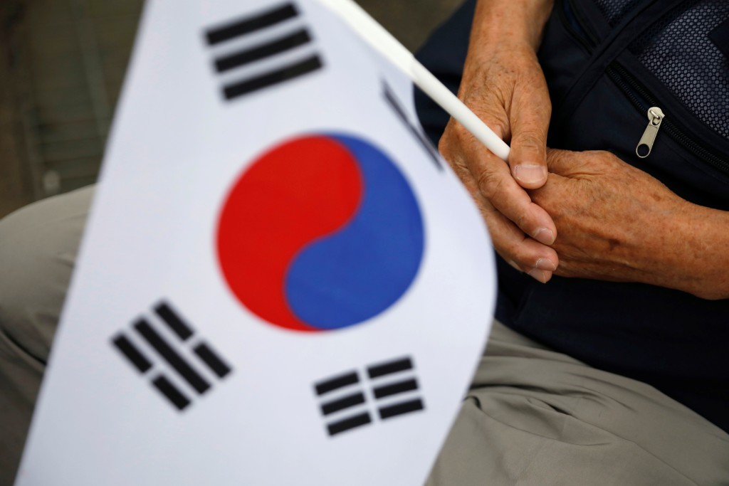 A South Korean war veteran holds the national flag during a ceremony commemorating the 70th anniversary of the Korean War, near the demilitarized zone separating the two Koreas, in Cheorwon, South Korea, June 25, 2020. REUTERS/Kim Hong-Ji