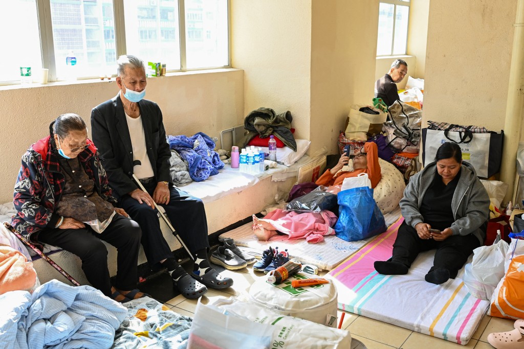Photo by PETER PARKS / AFP  Displaced residents are seen at a makeshift shelter inside a shopping mall near the scene of a major fire that swept through several apartment blocks at the Wang Fuk Court residential estate in Hong Kong's Tai Po district on November 28, 2025.
