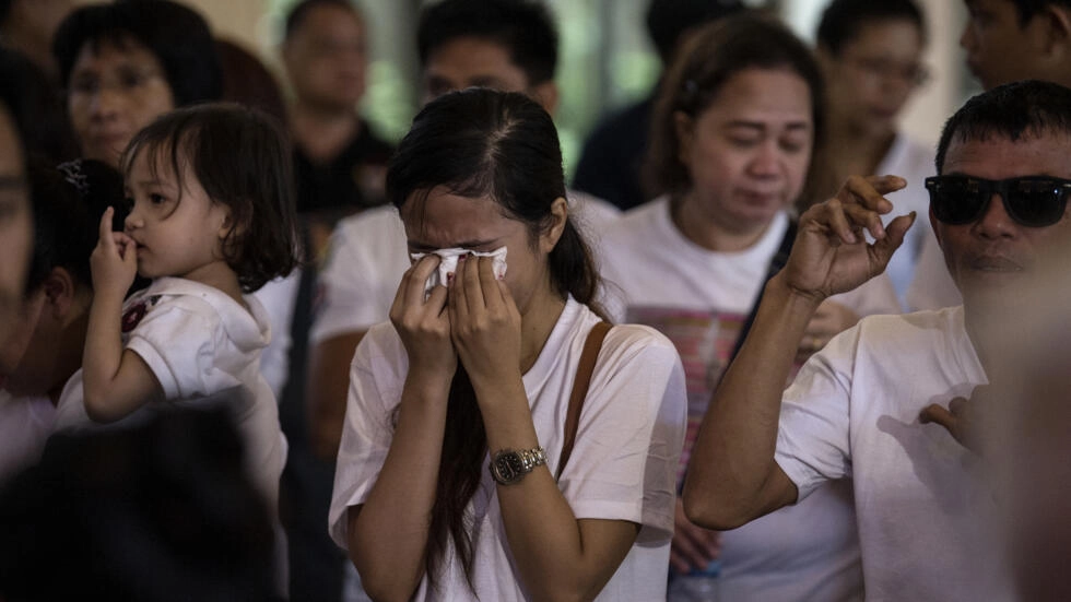 The sister of teenager Carl Arnaiz, who was killed by a Philippine police officer, cries at a mass ahead of his burial in 2017. (AFP) The sister of teenager Carl Arnaiz, who was killed by a Philippine police officer, cries at a mass ahead of his burial in 2017. (AFP)
