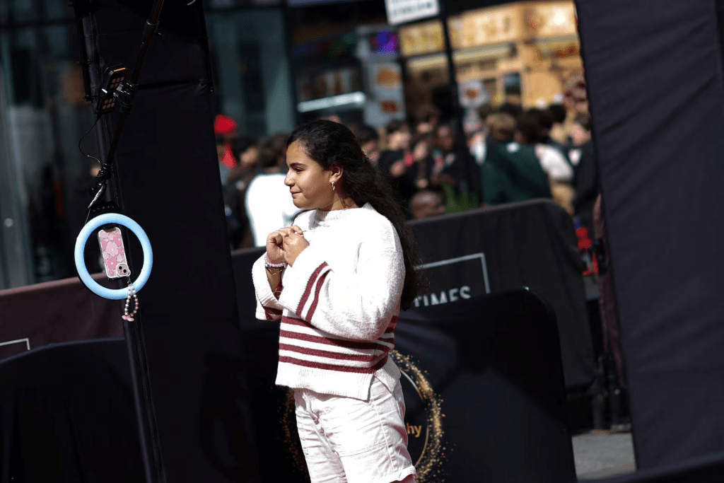A woman who said she was making a video to be posted on TikTok, poses in a booth that swirls a mobile phone around 360 degrees in Times Square in New York City, New York, U.S., March 13, 2024. REUTERS/Mike Segar 
