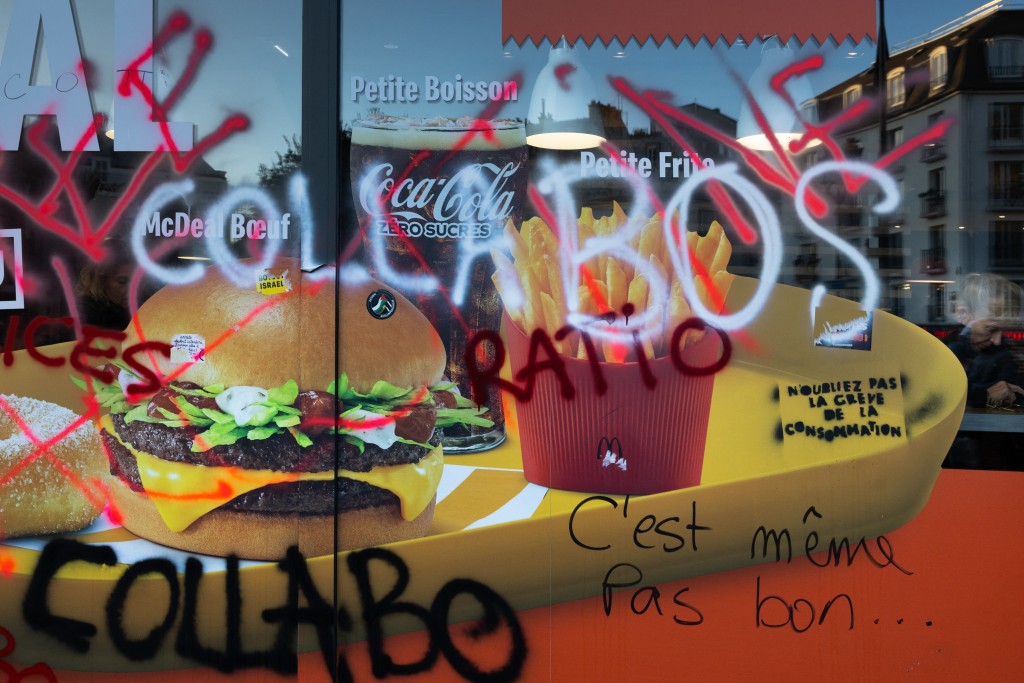This photograph shows the facade of a McDonald's fast food restaurant covered with graffitis reading "Collabos" (Collaborators) in Paris on October 18, 2026, a day after nationwide protests against the "high cost of living". (Photo by JOEL SAGET / AFP)