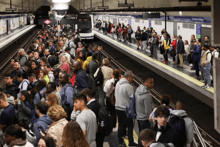 Passengers in the Spanish capital Madrid wait on a platform as metro operations resume partially, after power begins to return following a huge outage in Spain and Portugal [Violeta Santos Moura/Reuters]