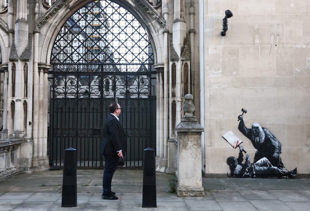 A person looks at a new mural by anonymous artist Banksy on the Royal Courts of Justice in London, Britain, September 9, 2025. (Reuters)