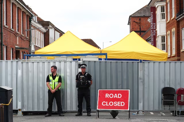 Police officers stand outside the street where Dawn Sturgess lived before dying after being exposed to a Novichok nerve agent, in Salisbury, Britain, July 19, 2018. REUTERS/Hannah McKay