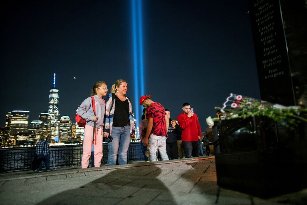 People pay respect for the victims at a memorial while the Tribute in Light art installation and the One World Trade Center are seen in the background. (Reuters) People pay respect for the victims at a memorial while the Tribute in Light art installation and the One World Trade Center are seen in the background. (Reuters)