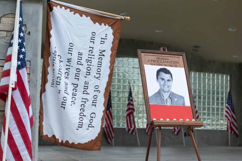 Candles are left in front of a photo of youth activist and influencer Charlie Kirk as people attend a vigil in Orem City Center Park, Orem, Utah, September 10, 2025.  (Photo by Melissa MAJCHRZAK / AFP)