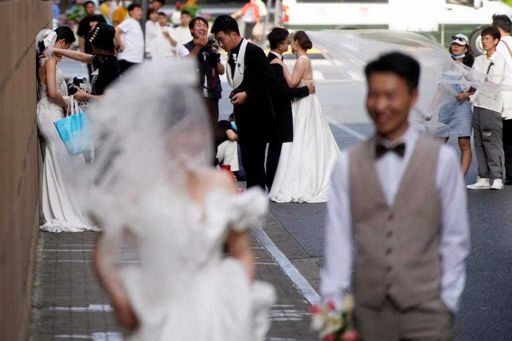 Couples prepare to have their photo taken during a wedding photo shoot on a street, amid the coronavirus disease (COVID-19) pandemic, in Shanghai, China May 31, 2021. REUTERS/Aly Song/File Photo 
