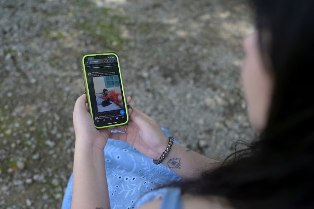 Julie Yukari, a musician based in Rio de Janeiro, holds a mobile phone showing a picture of her during an interview, after she discovered that Grok, the chatbot built into Elon Musk’s social media platform X, had generated nearly nude images of her when users requested edits to a photo she posted, in Rio Claro, Rio de Janeiro state, Brazil, January 3, 2026. REUTERS/Tita Barros